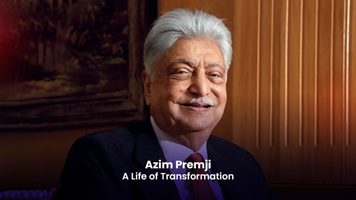 A photograph of Azim Premji, an Indian businessman and philanthropist, smiling. He has short gray hair and is wearing a suit and tie.